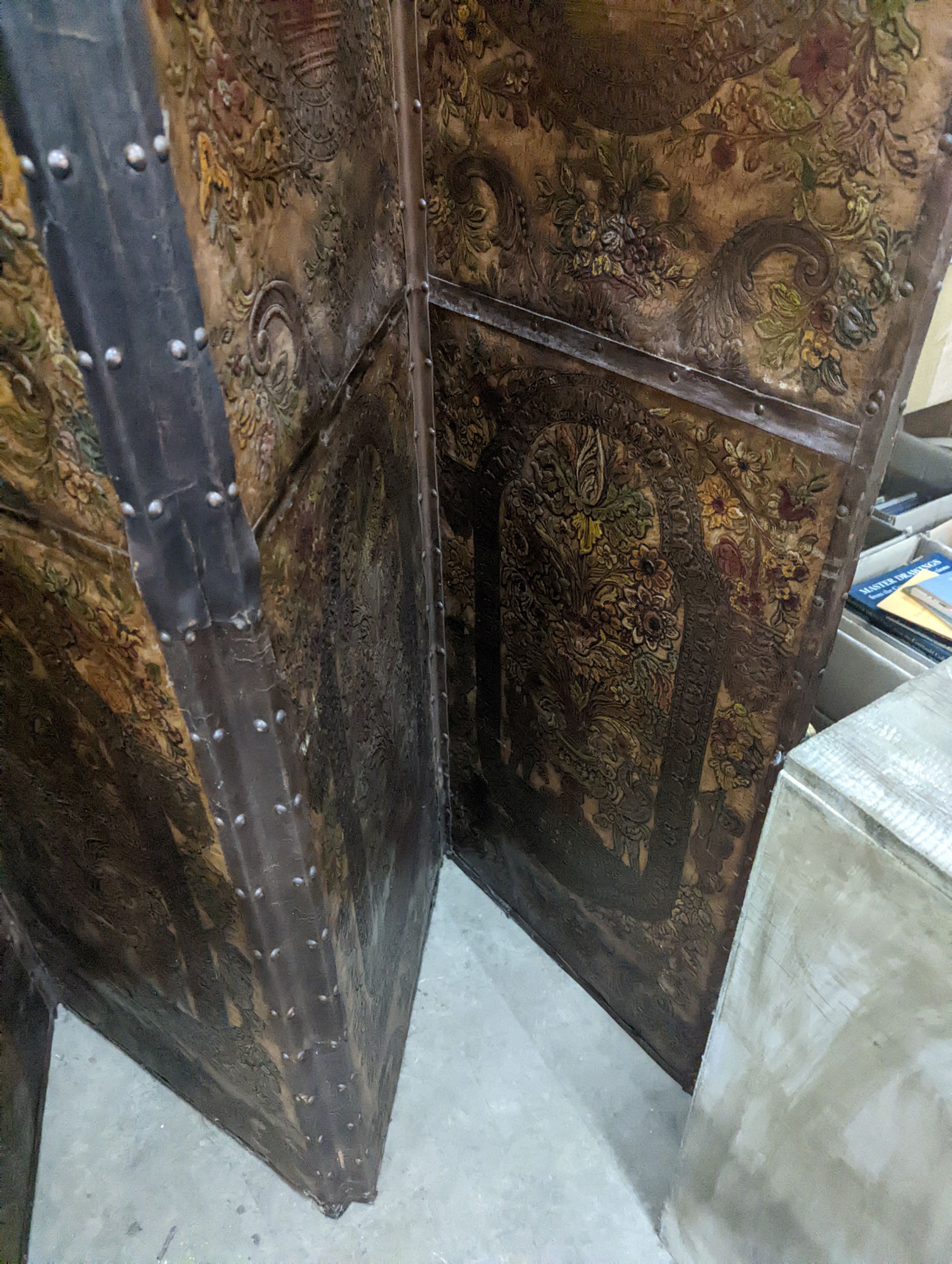 An embossed leather four fold dressing screen, each panel width 51cm, height 181cm